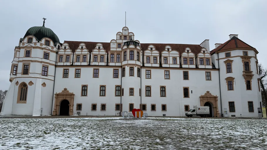Historisches Schloss in verschneiter Landschaft.