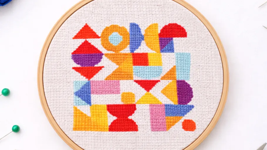 Colorful geometric embroidery in wooden hoop.