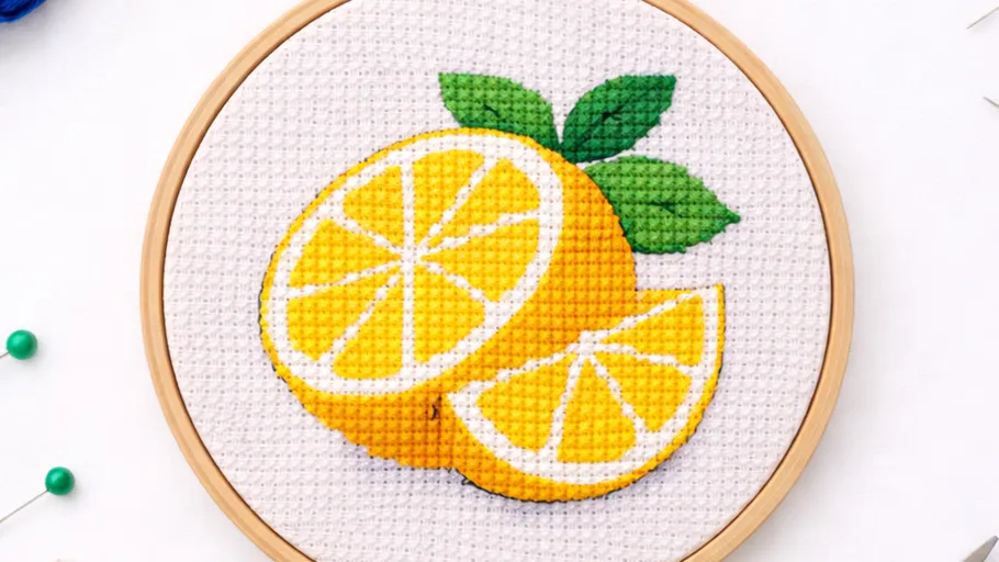 Kreuzstich Zitrone mit grünen Blättern, Holzrahmen.