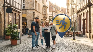 Gruppe schaut auf Tablet in Kopfsteinpflasterstraße.