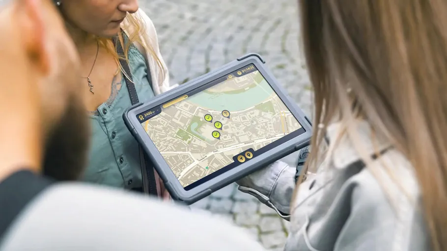 People looking at a map on a tablet outdoors.