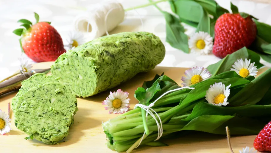 Herb butter roll on wooden board with strawberries.