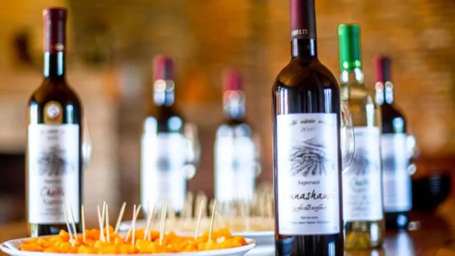 Wine bottles on table with appetizers.