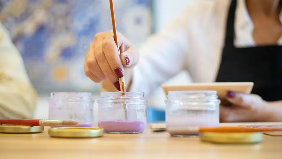 Person painting with brush in art studio.