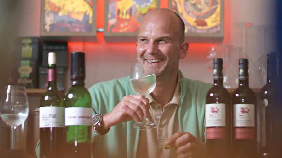 Man drinking wine in a cozy setting.