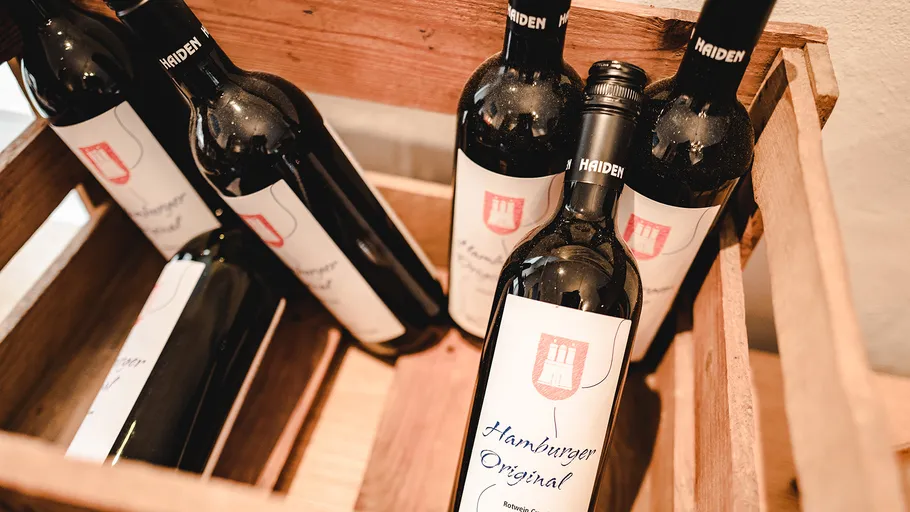 Wine bottles labeled 'Hamburger Original' in a crate.