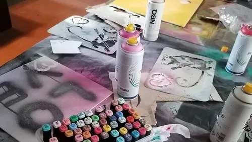 Spray paint cans and stencils on table.