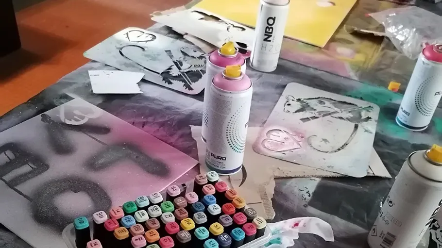 Sprühdosen und Schablonen auf Tisch.