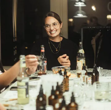 Woman wearing glasses smiling at dinner table.