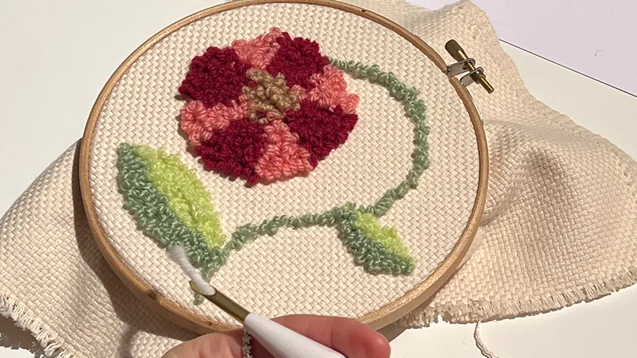 Flower embroidery in hoop on fabric.
