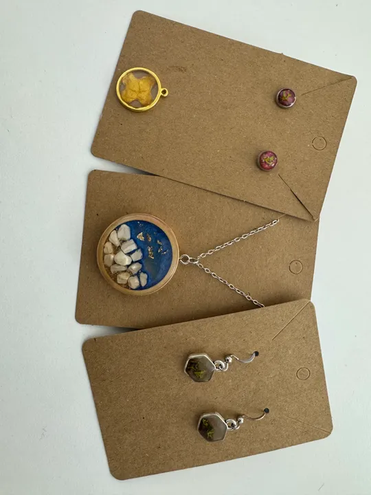 Handgemachter Schmuck auf braunen Papierkarten.