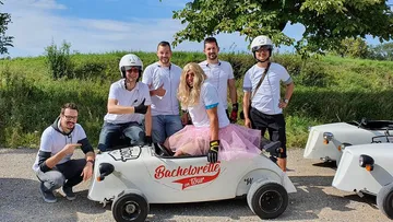 Gruppe von Personen mit einem Go-Kart im Freien.