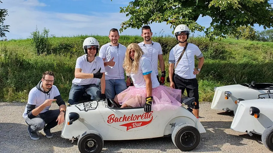 Group of people with a go-kart outdoors.