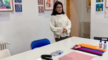 Woman standing in colorful art classroom.