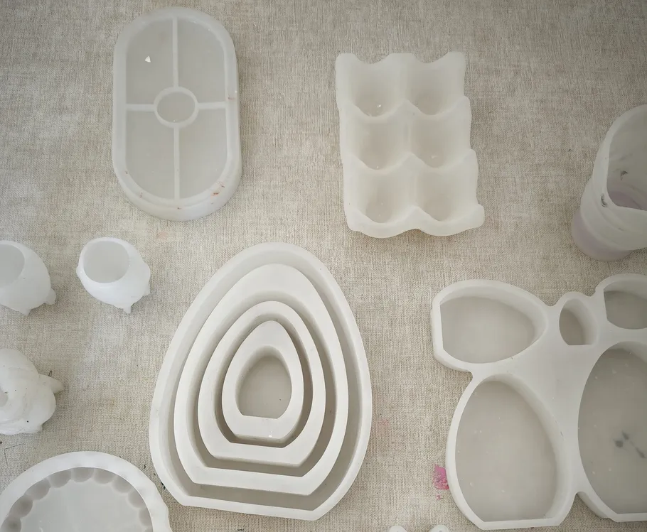 Various silicone molds on a beige surface.