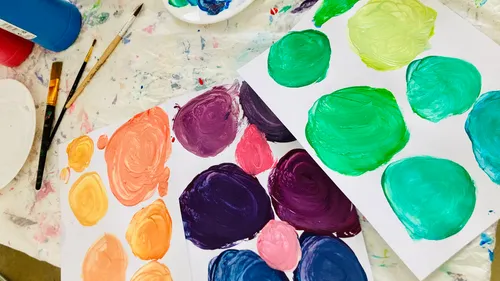 Painted colorful circles on scattered papers.