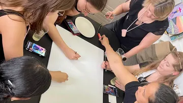 Group drawing together on a large paper.