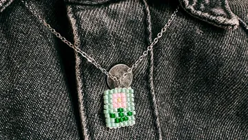 Beaded pendant on a denim jacket.