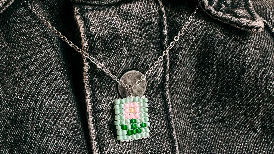 Beaded pendant on a denim jacket.