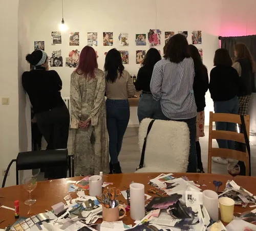 People observe a collage display in a room.