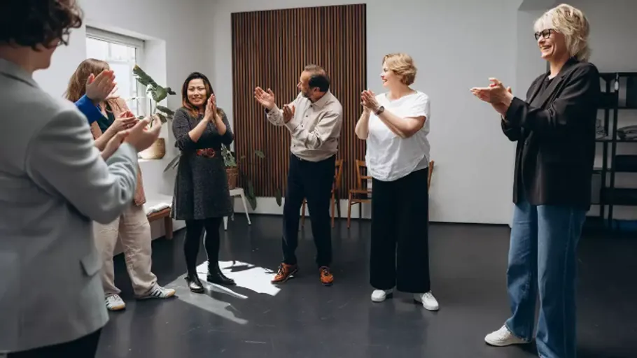 Gruppe von Menschen klatscht in einem Raum.