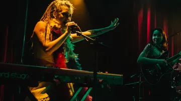Musicians performing passionately on stage with instruments.