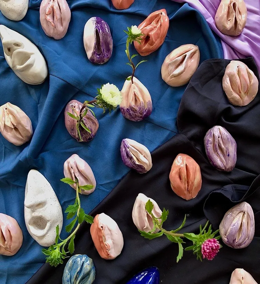 Ceramic sculptures on colorful fabrics with flowers.