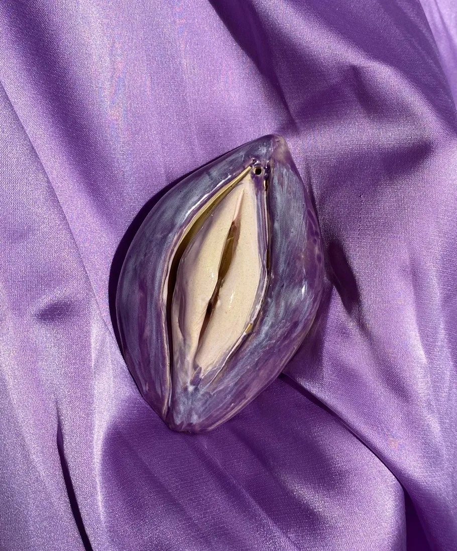 Ceramic sculpture on purple fabric background.