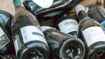 Dusty wine bottles lying in a heap.