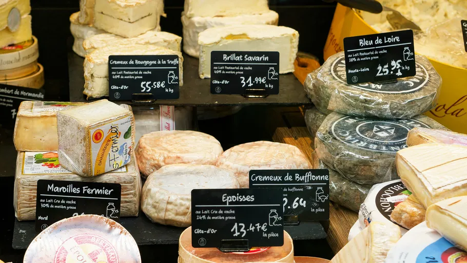 Various cheeses displayed with price tags.