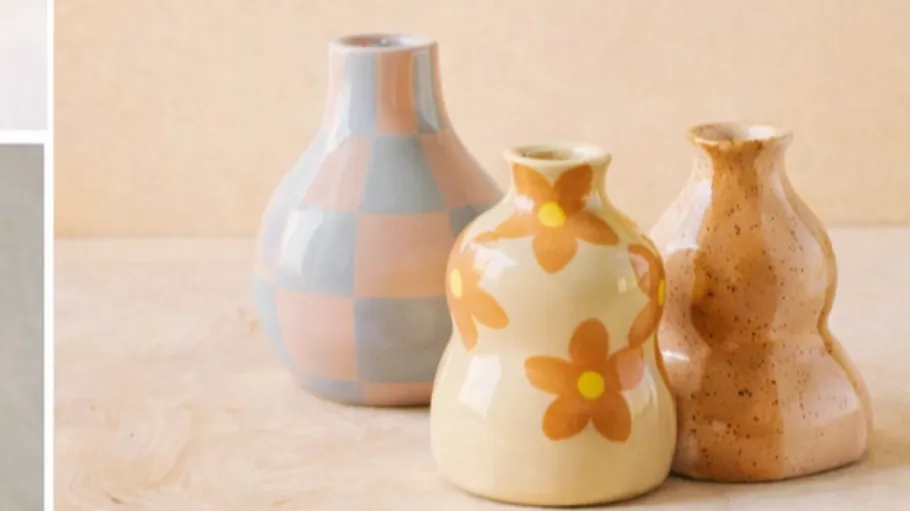 Three decorative vases on wooden surface.