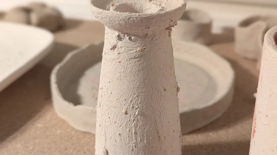 Rough, handmade ceramic vase on a table.