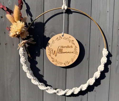 Decorative wreath with welcome sign on wood.