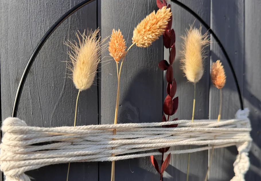Dried grasses and twine on wooden fence.