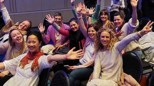 Group of women celebrating indoors, smiling happily.