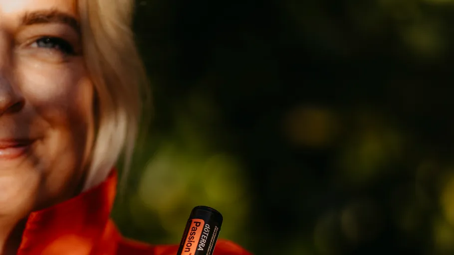 Person hält doTERRA Passion Ölflasche im Freien.