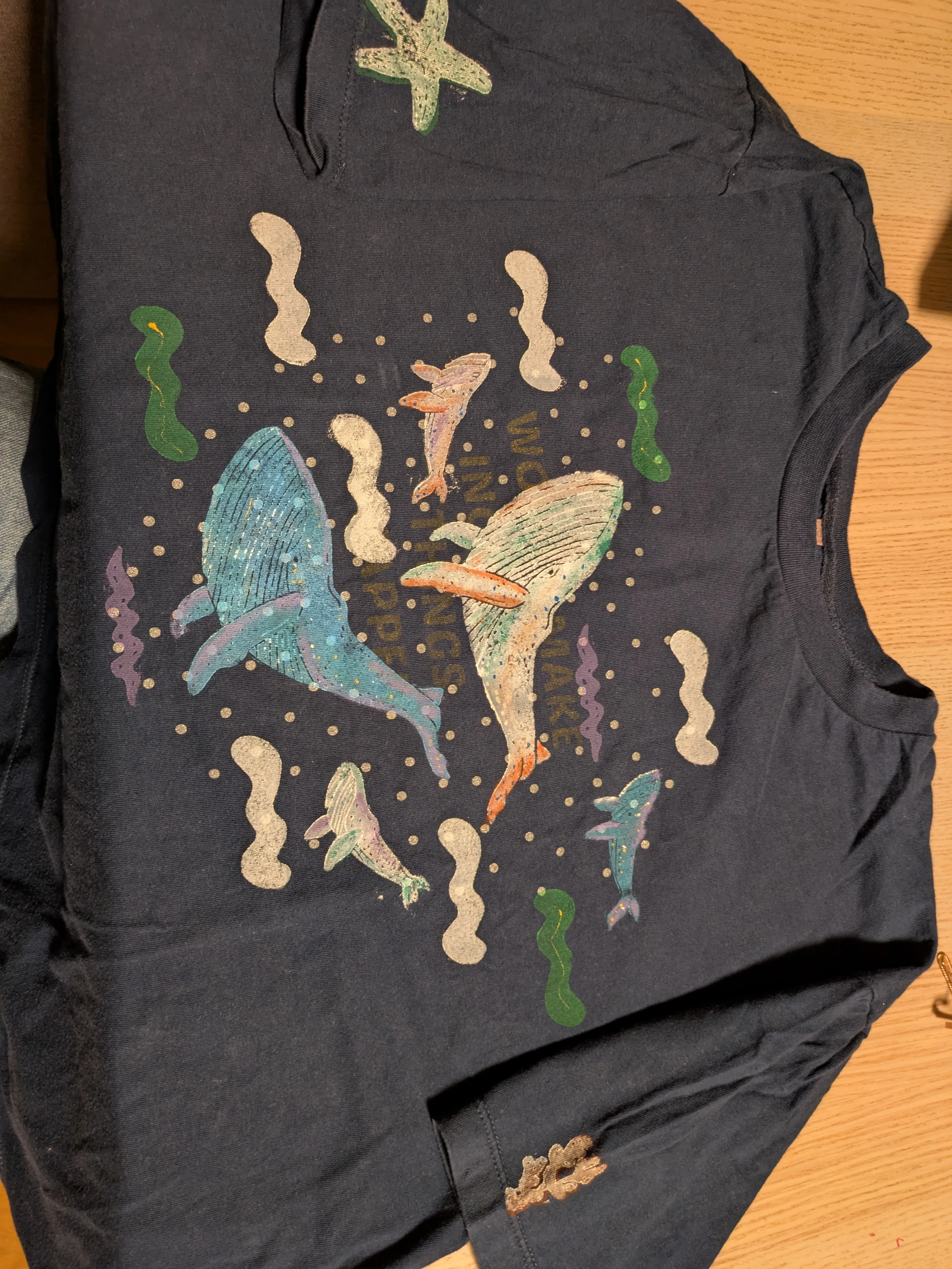 T-Shirt mit Meerestier-Illustrationen auf Holz.