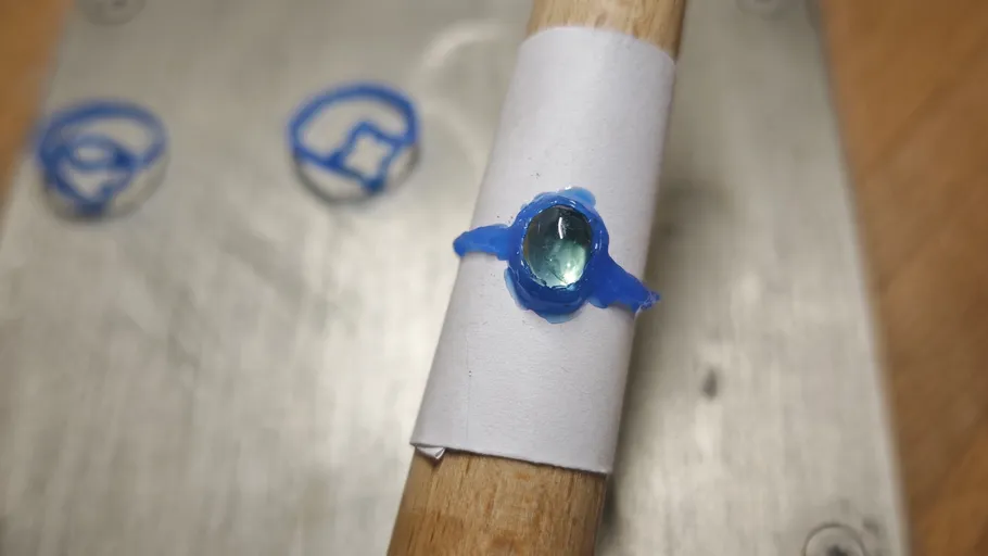 Blue ring model on wooden stick surface.