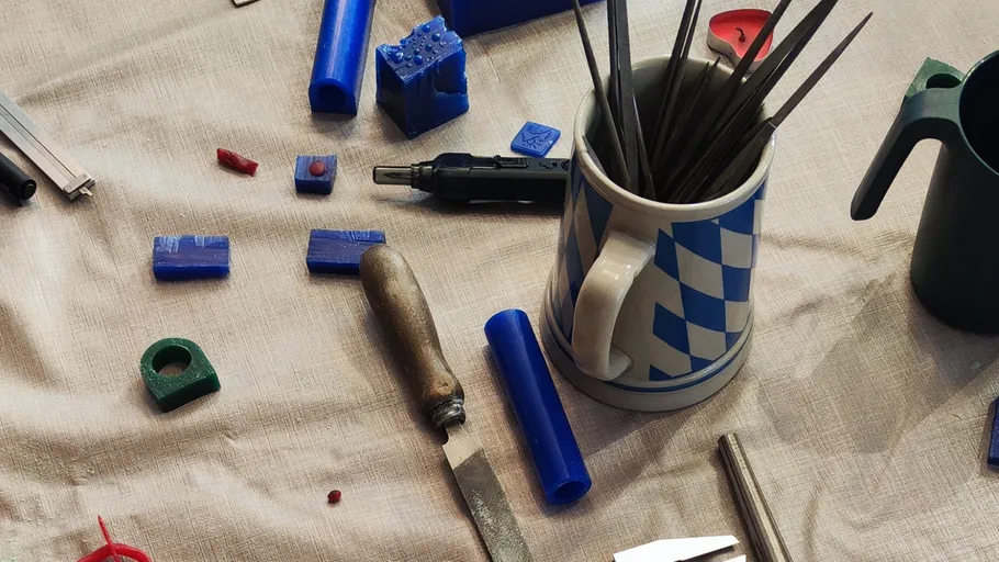 Craft tools with blue wax on table.