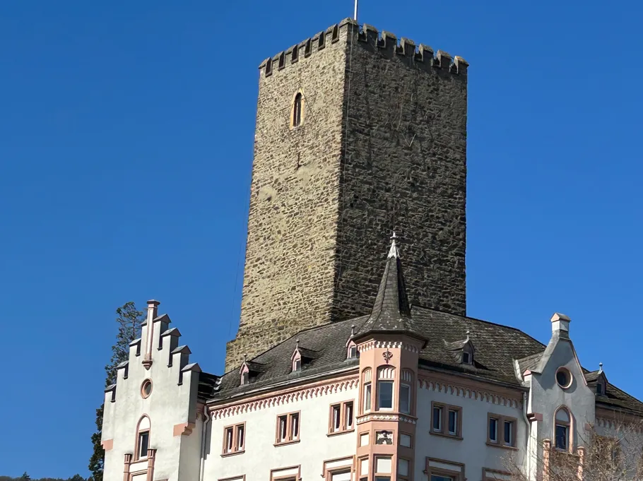 Hoch steinerner Turm über altem europäischem Gebäude.