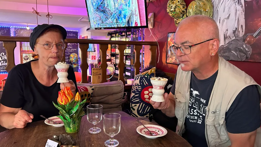 Two people enjoy ice cream in a cozy cafe.