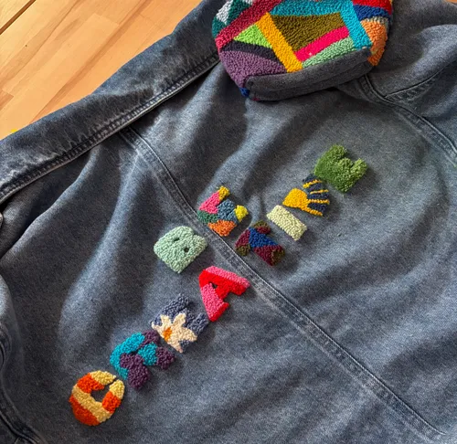Denim jacket with colorful embroidery design.