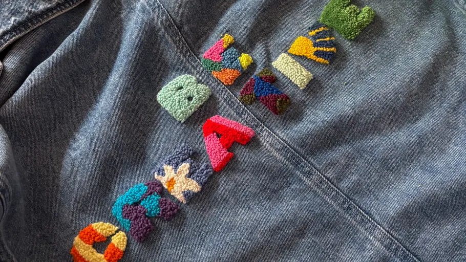 Jeansjacke mit buntem Stickdesign.