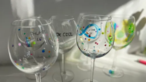 Decorated glasses with colorful dots in sunlight.
