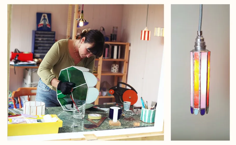 Woman crafting stained glass lamp in workshop.