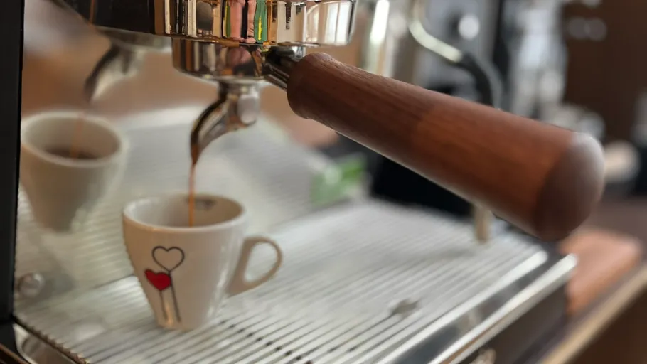 Espressomaschine gießt Kaffee in Tasse.