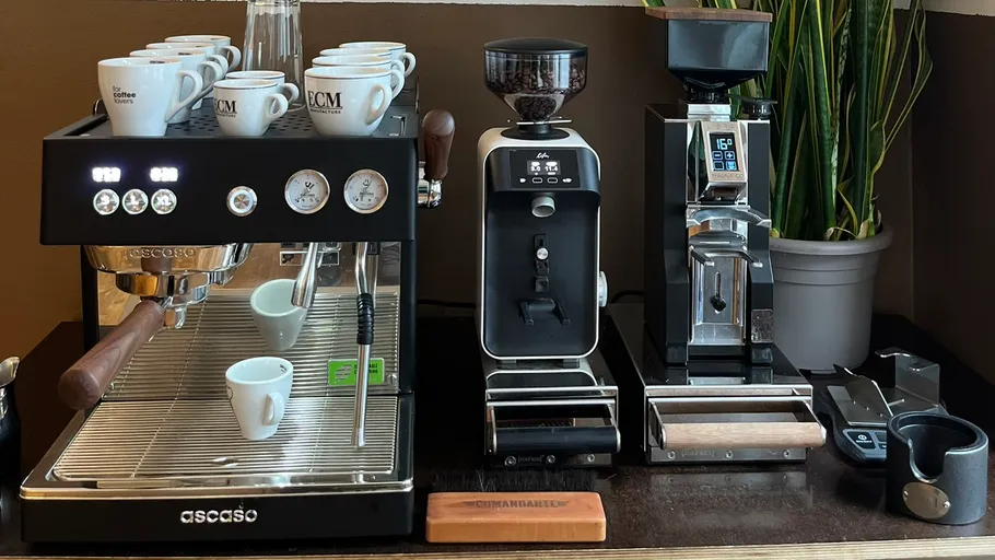 Kaffeemaschinen mit Tassen auf einer Holztheke.