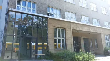 Building with glass entrance and multiple windows.