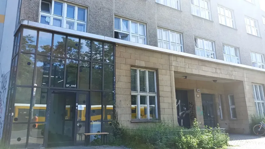 Building with glass entrance and multiple windows.
