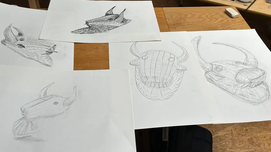 Five sketches of bull heads on a table.